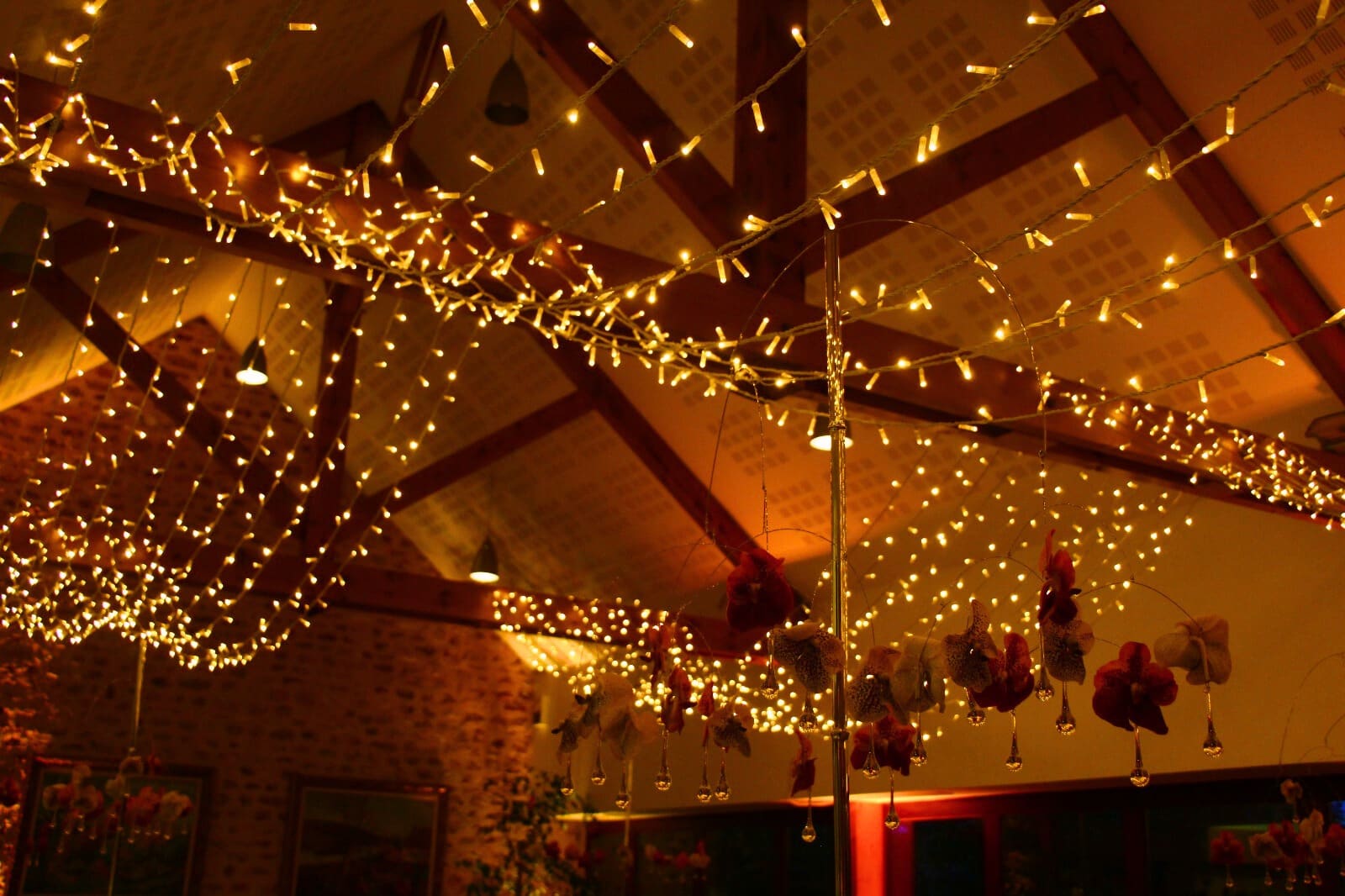 Réception privée dressée sous chapiteau, guirlandes lumineuses et tables rondes